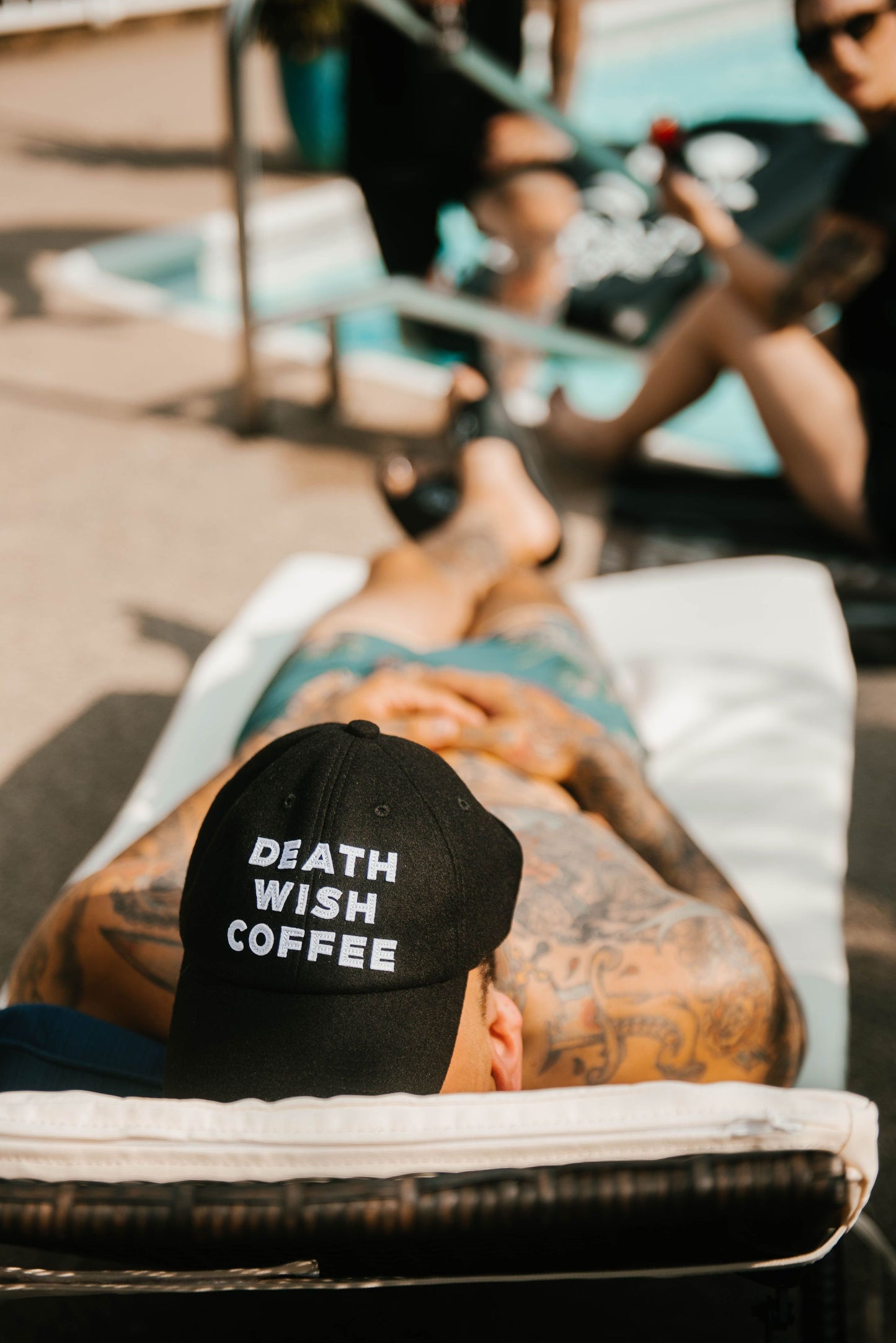 Man lying down wearing a Death Wish Coffee Baseball Hat